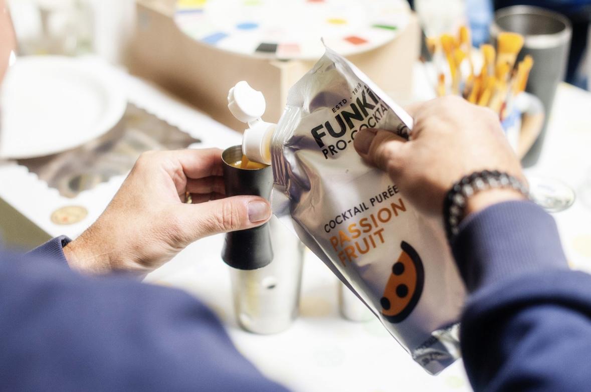 Close up of passion fruit puree being poured into a jigger